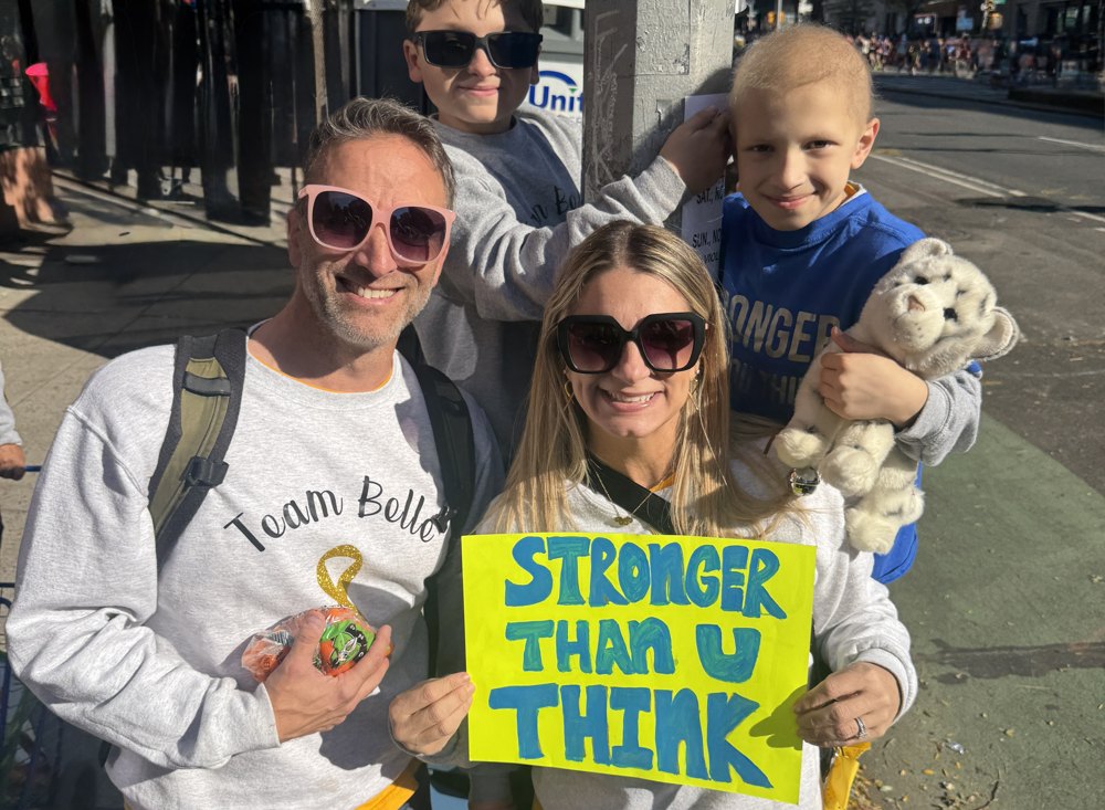 Belle's family holding a Stronger Than U Think sign in Team Belle shirts