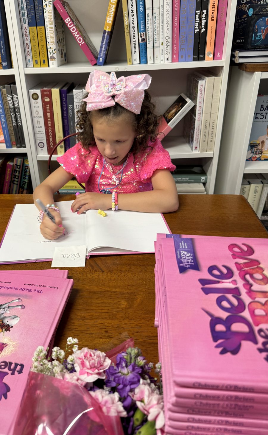 Belle signing copies of her book