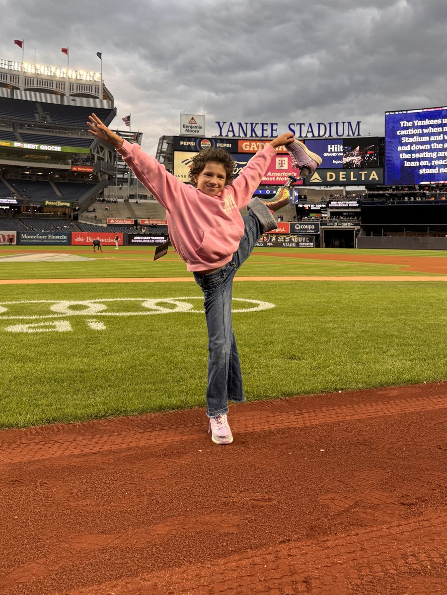 Belle doing a high kick on the field at Yankee Stadium